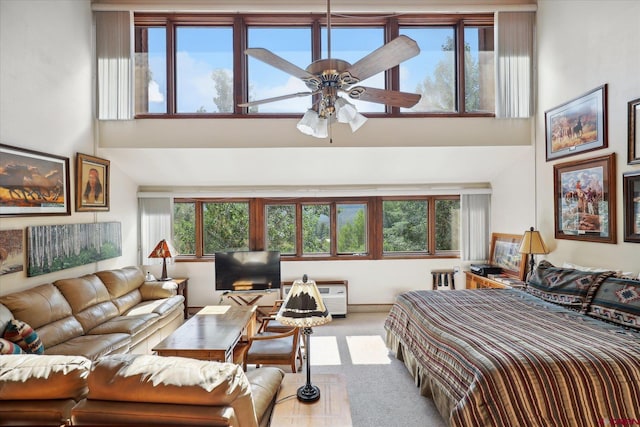 bedroom featuring a towering ceiling, carpet floors, and ceiling fan