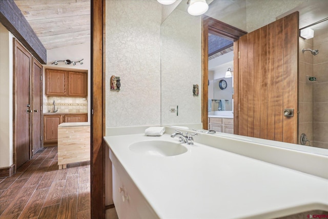 bathroom with hardwood / wood-style floors, vanity, tasteful backsplash, and vaulted ceiling