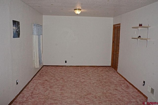 carpeted spare room with a textured ceiling