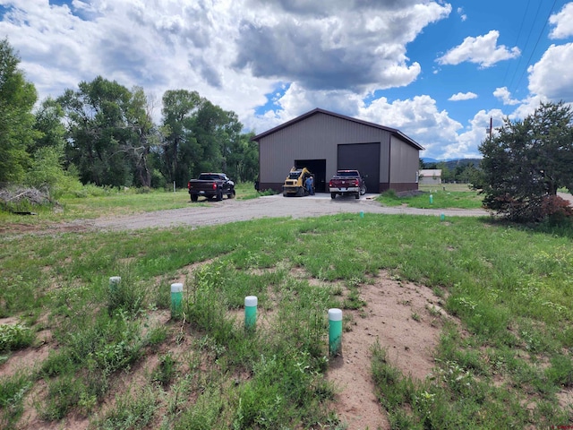 view of yard featuring a garage and an outbuilding