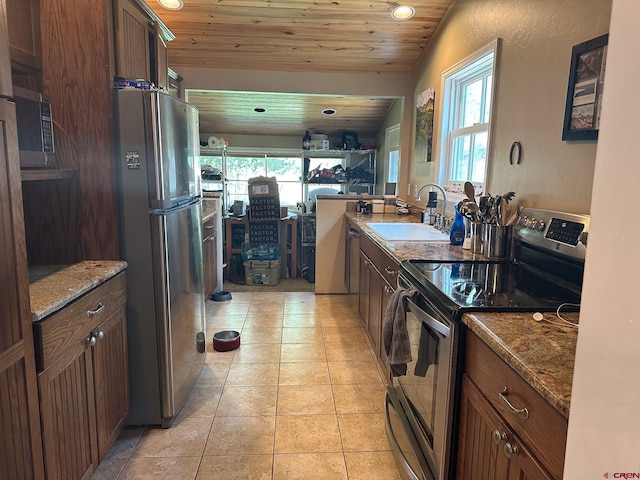 kitchen with light tile patterned flooring, light stone counters, wood ceiling, stainless steel appliances, and sink