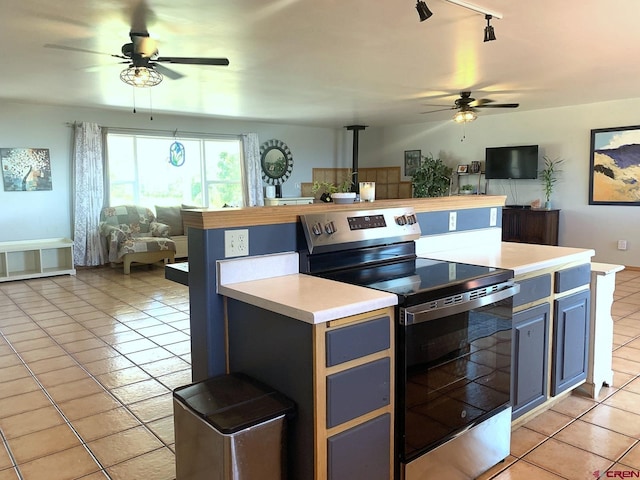 kitchen featuring ceiling fan, stainless steel electric stove, light tile patterned floors, and track lighting