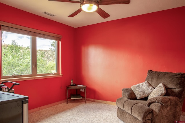 living area with carpet flooring, visible vents, ceiling fan, and baseboards