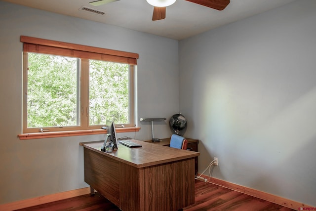 office area featuring a ceiling fan, visible vents, dark wood finished floors, and baseboards