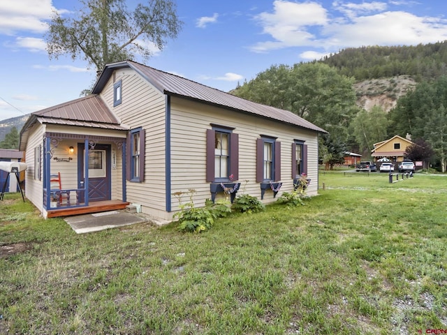 view of side of home with metal roof and a yard