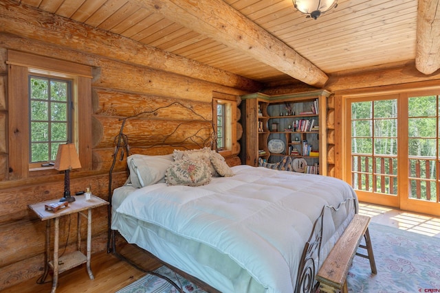 bedroom featuring log walls, multiple windows, hardwood / wood-style floors, and beam ceiling