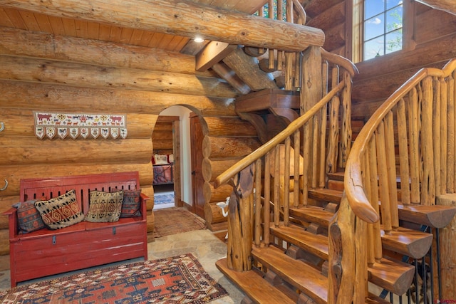 staircase featuring beamed ceiling, wooden ceiling, tile patterned flooring, and rustic walls