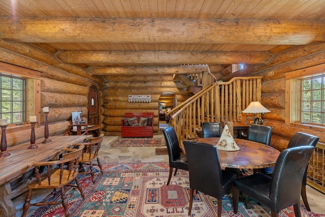 dining area with beamed ceiling, wooden ceiling, and rustic walls