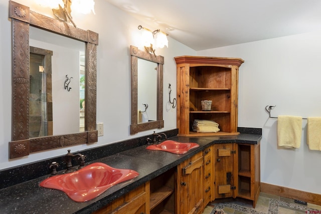 bathroom featuring walk in shower, tile patterned flooring, and dual bowl vanity