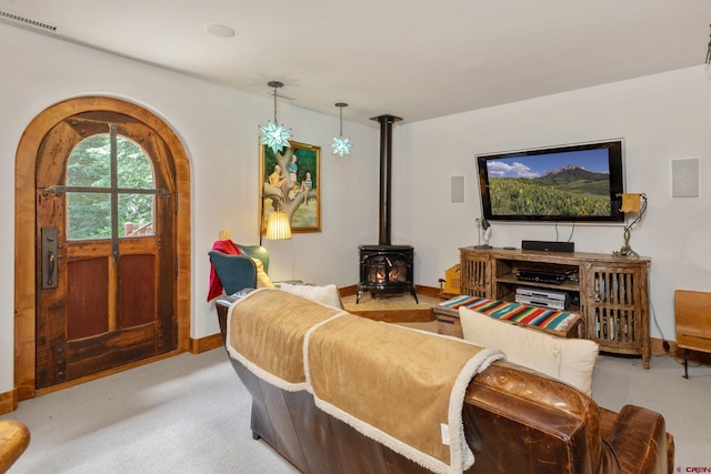 living room with light carpet and a wood stove