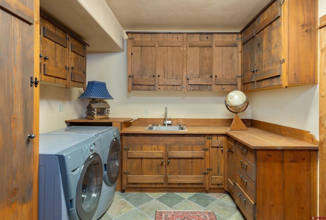 washroom featuring washer and clothes dryer, sink, cabinets, and light tile patterned floors