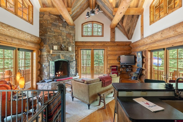 living room with beam ceiling, plenty of natural light, and rustic walls