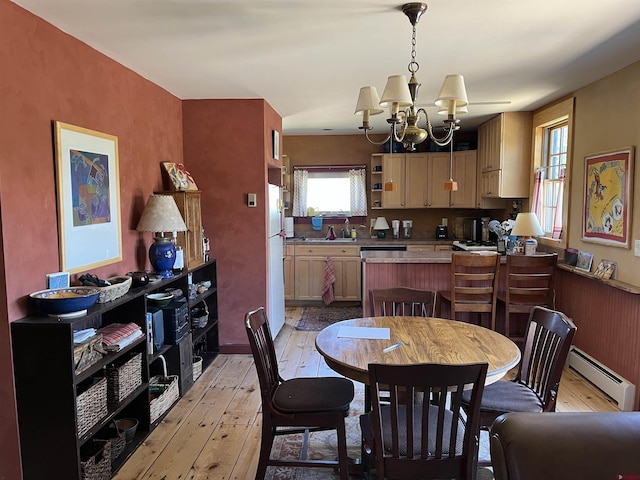 dining room featuring a baseboard radiator, light hardwood / wood-style flooring, and a notable chandelier