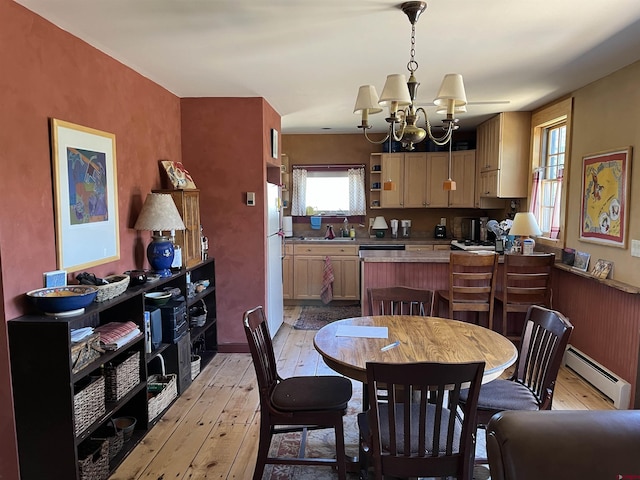 dining area featuring a baseboard radiator, a chandelier, and light wood-type flooring