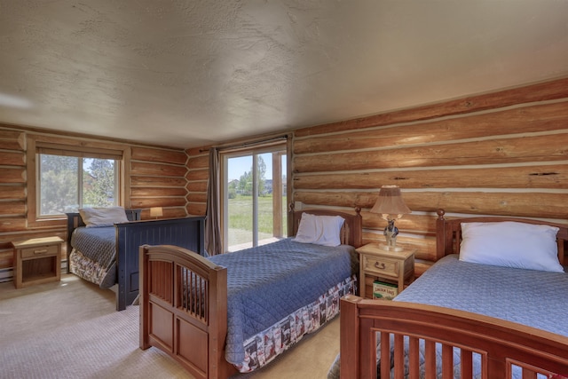 carpeted bedroom with log walls, access to exterior, and a textured ceiling