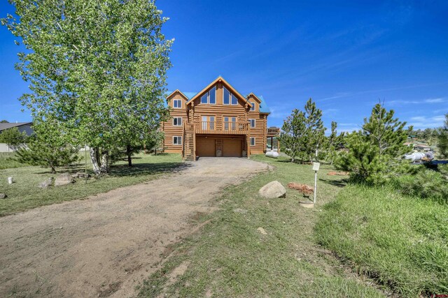 cabin featuring a wooden deck and a front lawn