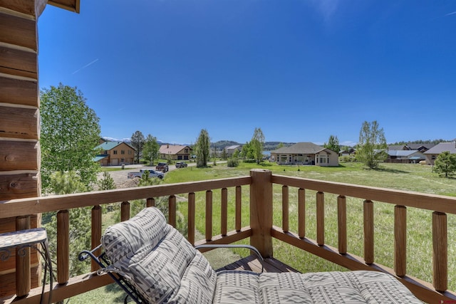 wooden deck featuring a lawn