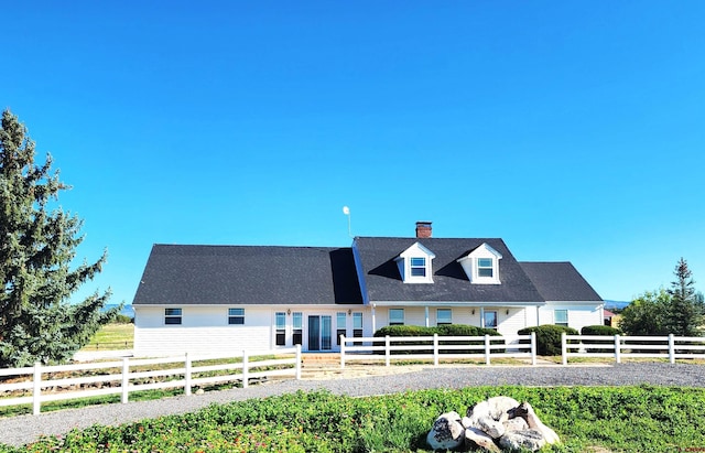 new england style home featuring a chimney and fence