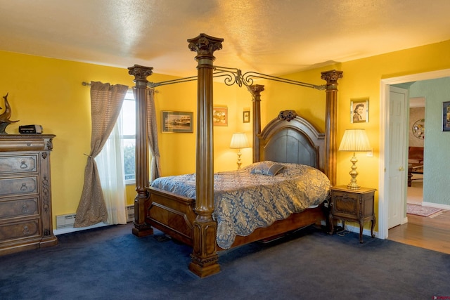 bedroom with a baseboard heating unit, carpet, and ornate columns