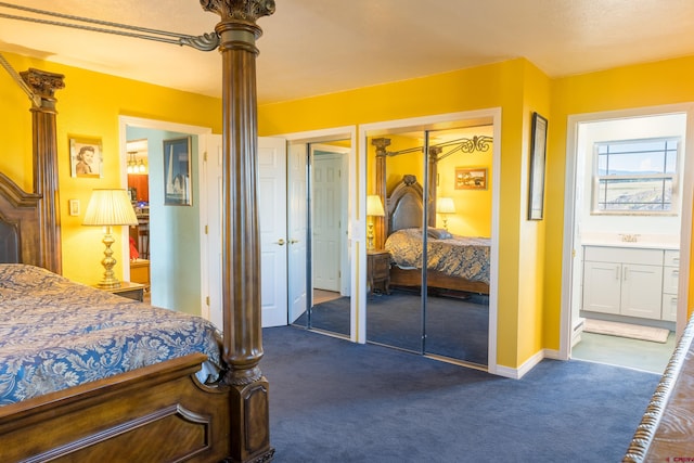 bedroom featuring ensuite bathroom, dark colored carpet, a sink, and ornate columns