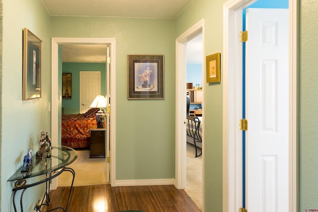 hall with dark wood-style floors and baseboards