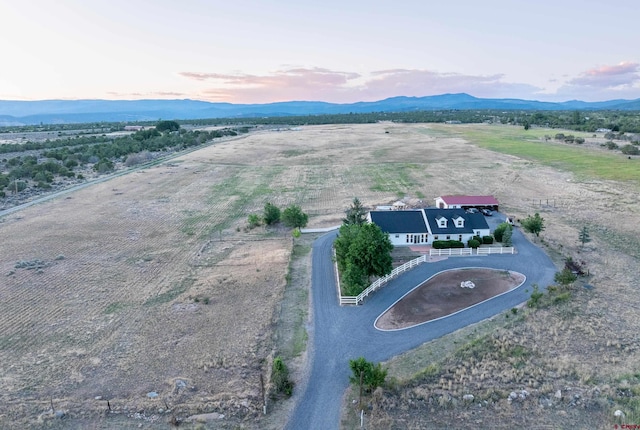 aerial view at dusk with a mountain view and a rural view