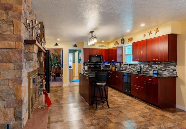 kitchen featuring tasteful backsplash, a kitchen island, black appliances, hanging light fixtures, and sink