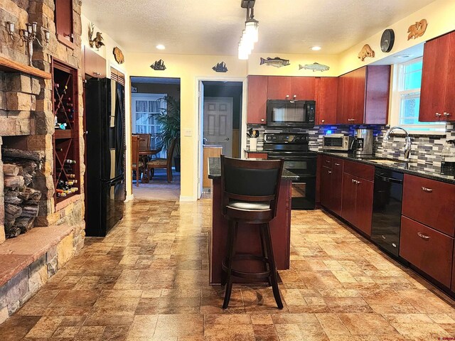 kitchen with black appliances, a chandelier, a kitchen island, a textured ceiling, and tile patterned flooring