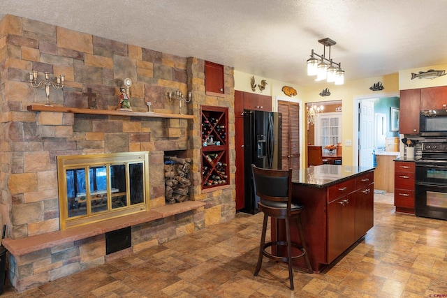 kitchen with black fridge with ice dispenser, dark countertops, stove, a textured ceiling, and a fireplace