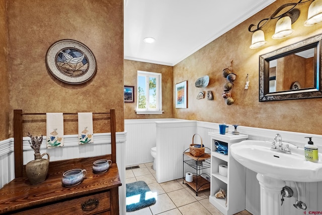 bathroom featuring tile patterned flooring, toilet, and crown molding