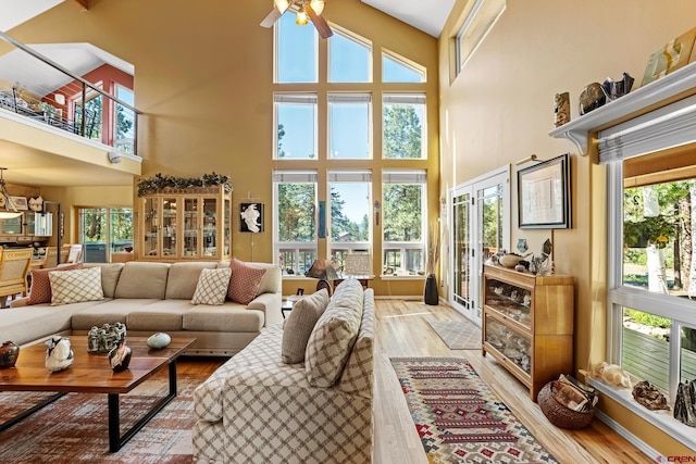 interior space with a high ceiling, light hardwood / wood-style floors, and ceiling fan