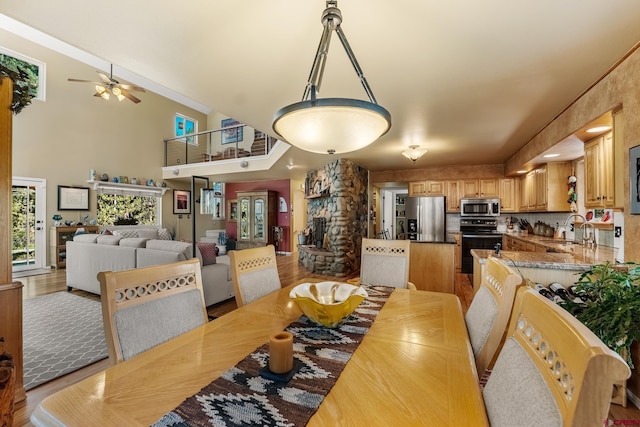 dining space featuring ceiling fan, light wood-type flooring, and sink