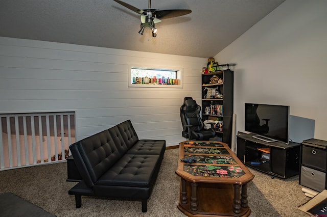 interior space featuring ceiling fan, vaulted ceiling, a textured ceiling, and wood walls