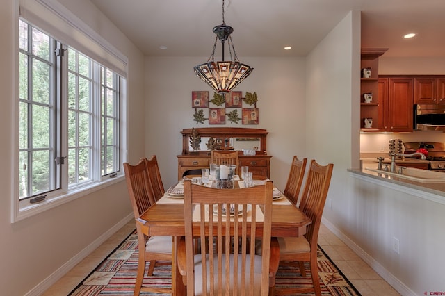 dining area featuring sink, a notable chandelier, and light tile patterned flooring