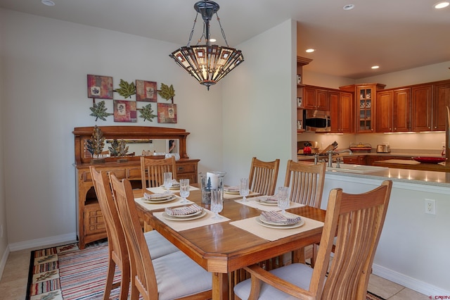 tiled dining space with an inviting chandelier and sink