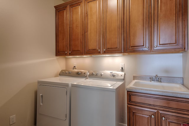 laundry area with cabinets, washing machine and dryer, and sink