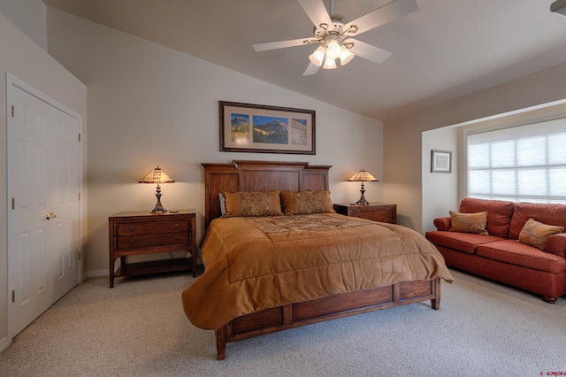 bedroom with ceiling fan, light colored carpet, lofted ceiling, and a closet