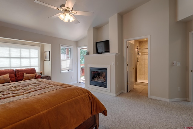 bedroom featuring ensuite bathroom, ceiling fan, light carpet, and vaulted ceiling