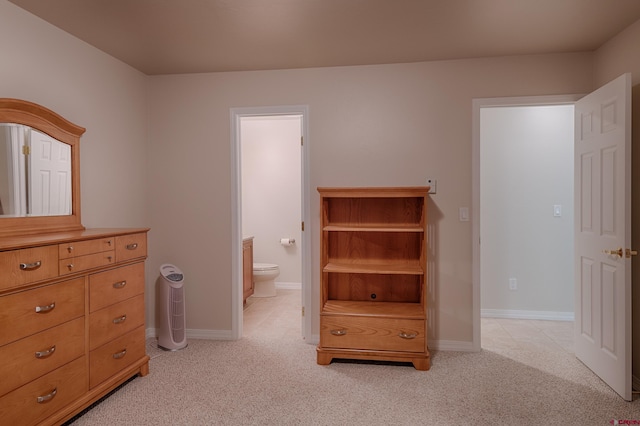 bedroom with light colored carpet and connected bathroom