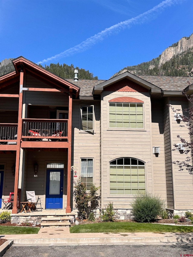 view of front of house featuring a mountain view and a balcony