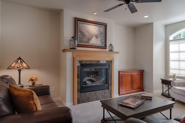 living room featuring carpet, a fireplace, and ceiling fan