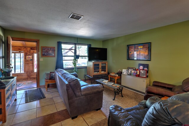 tiled living room featuring a textured ceiling