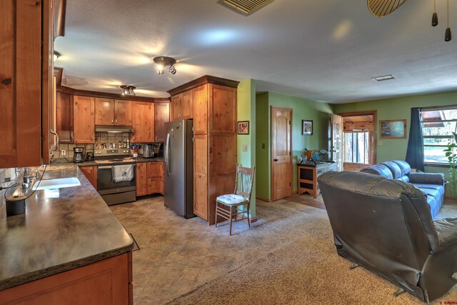 kitchen featuring backsplash, sink, appliances with stainless steel finishes, and light tile patterned floors