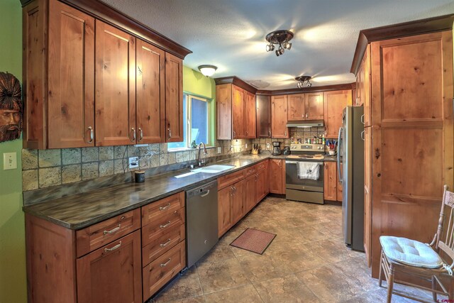 kitchen with sink, appliances with stainless steel finishes, tasteful backsplash, and tile patterned floors