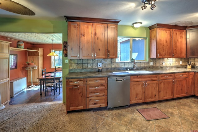 kitchen featuring a sink, dark countertops, decorative backsplash, and dishwasher