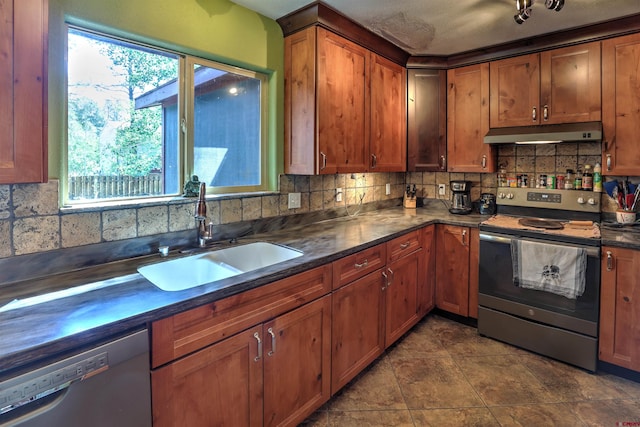 kitchen with sink, tile patterned floors, tasteful backsplash, and stainless steel appliances