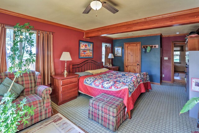 carpeted bedroom featuring beam ceiling and ceiling fan