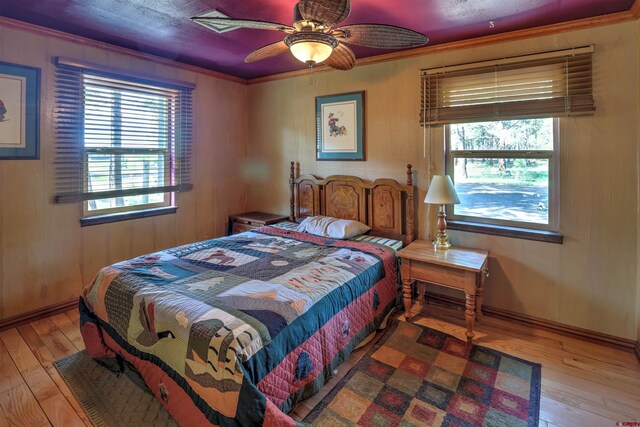 bedroom featuring crown molding, multiple windows, ceiling fan, and wood-type flooring