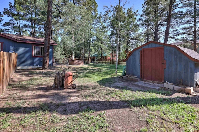 view of yard with an outbuilding, a storage unit, and fence