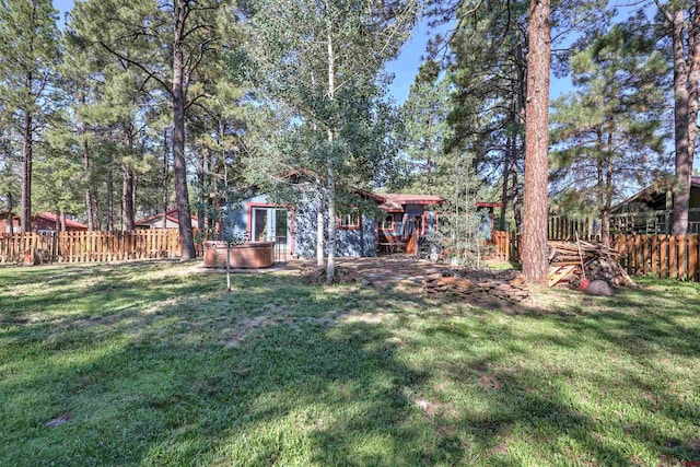 view of yard with a hot tub and fence